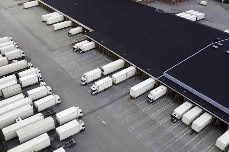 Camions sur un quai logistique – activité de transport et de distribution / Trucks at a logistics dock – transport and distribution activity